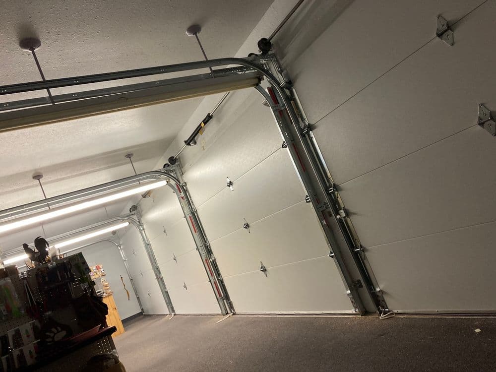 Spacious garage interior with two large doors and organized tools on a workbench.