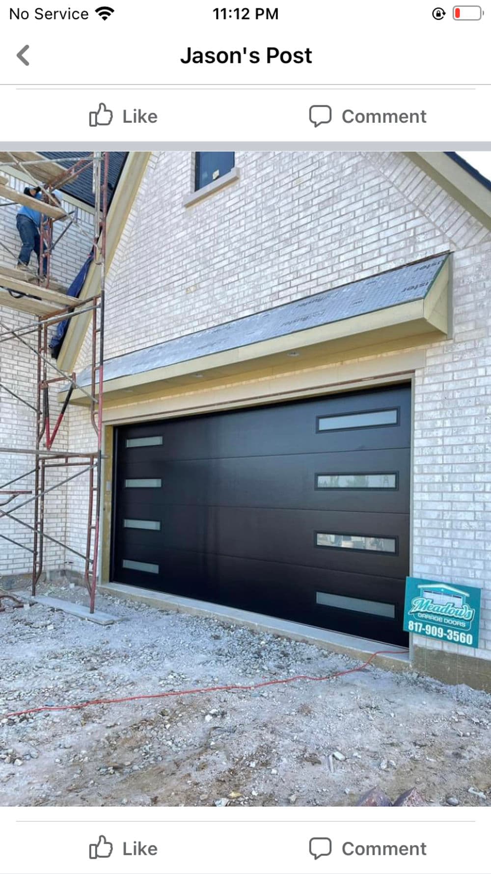 Modern black garage door with horizontal glass panels on newly constructed house.